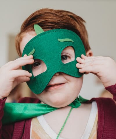 Dziecko w zielonej masce superbohatera bawiące się w przedszkolu Malinowy Domek w Krakowie