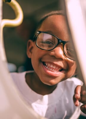 Uśmiechnięty chłopiec w okularach podczas zajęć w przedszkolu